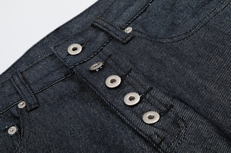 Close-up of button fly and front pocket stitching on dark wash denim jorts