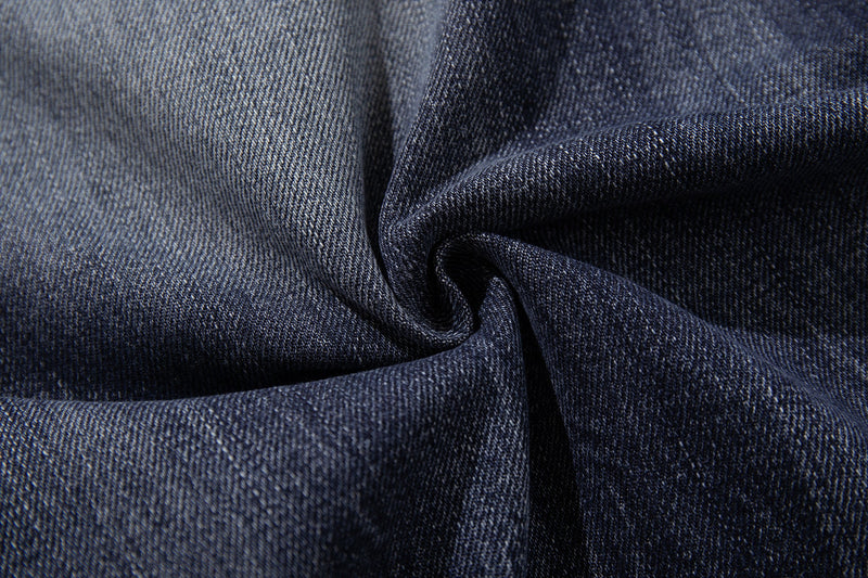 Close-up of deep indigo denim fabric showing smooth texture and washed fading