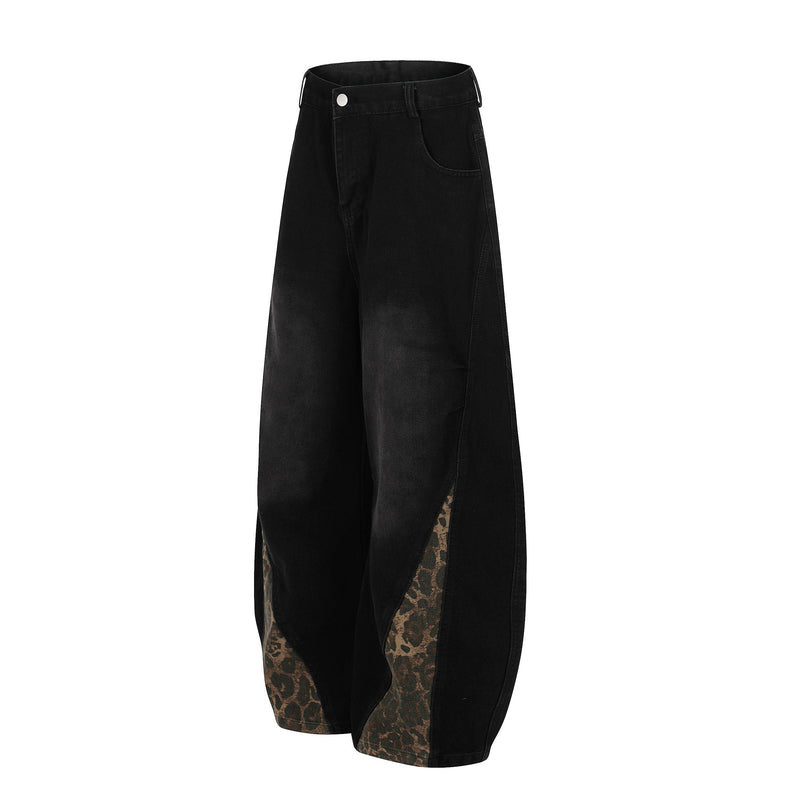 Angled back view of black wide-leg denim jeans with leopard-print panel details