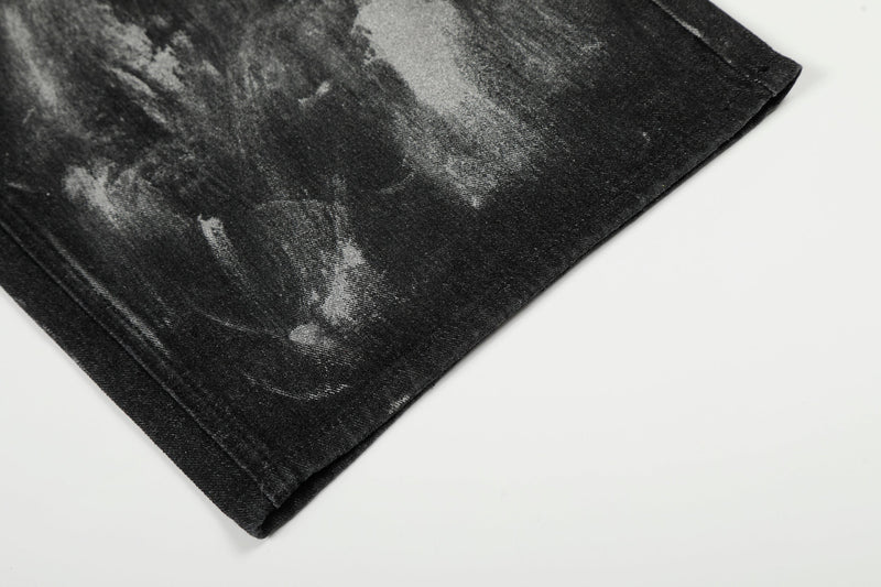 Close-up of hem on black painted wide-leg jeans with folded cuff