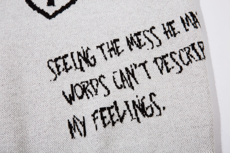 Close-up of black embroidered handwritten text on white knit sweater back