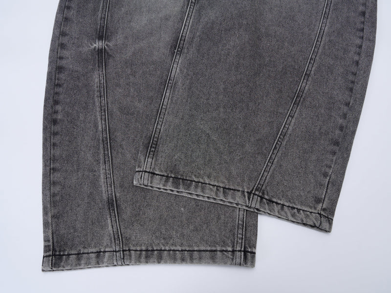 Close-up of hem and leg opening on grey washed denim jeans