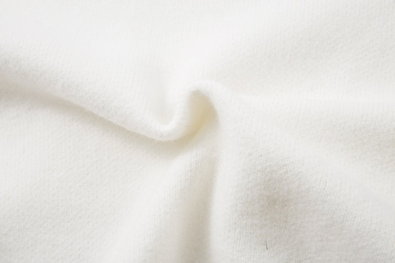 Close-up of white sweater hem with ribbed knit edge and smooth knit body