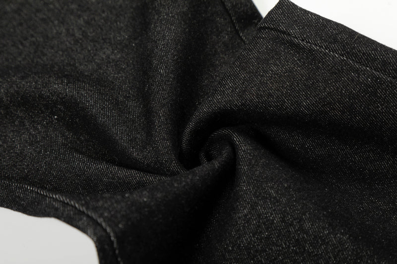 Close-up of black denim fabric gathered in folds