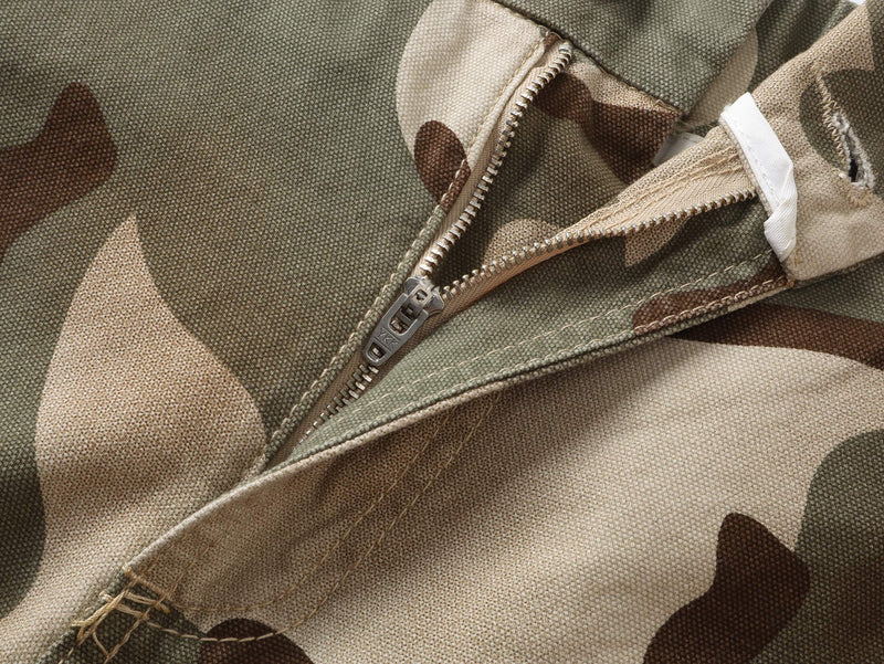 Close-up of camouflage pants fly with silver zipper and stitched front seam