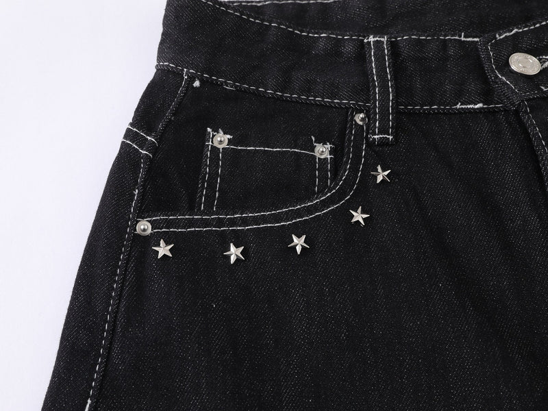 Close-up of front left pocket on black jeans with star studs and white stitching
