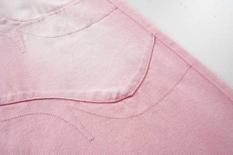 Close-up of pink washed denim back panel with curved seam stitching