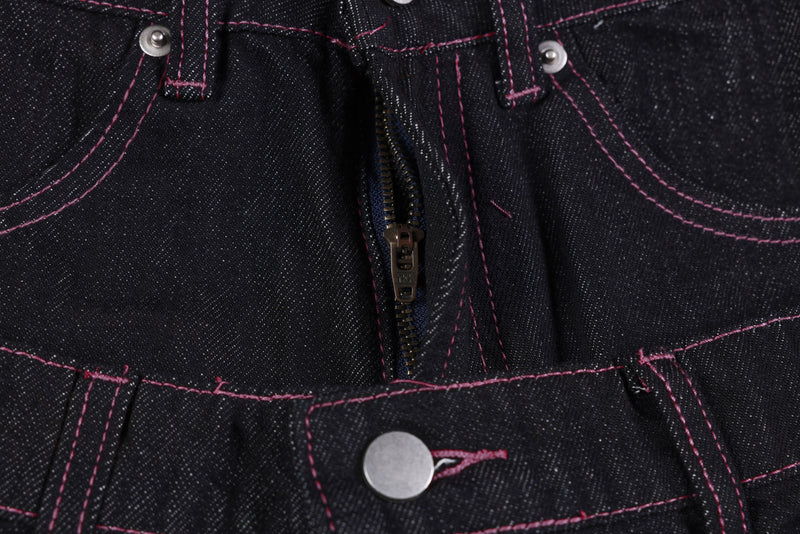 Close-up of the front fly zipper and top button on black denim pants