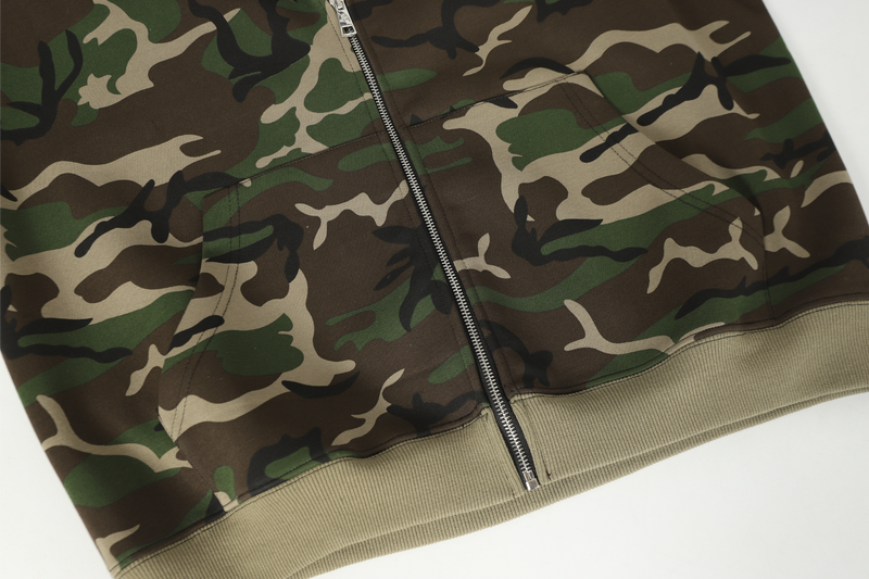 Lower front of camo zip hoodie with beige ribbed hem and zipper