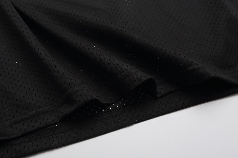 Close-up of black perforated mesh fabric on a varsity football jersey T-shirt with a sleek streetwear look