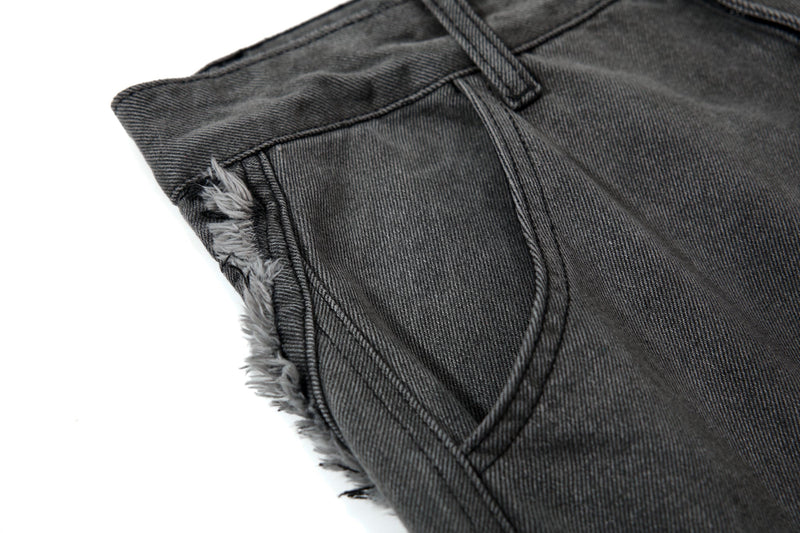 Close-up of side waistband and frayed seam detail on black cargo jeans