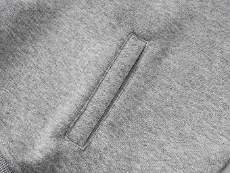 Close-up of gray hoodie front pocket seam on heather gray fabric