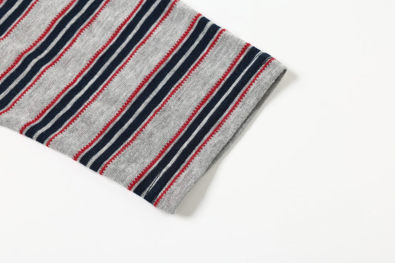 Close-up of gray long sleeve cuff with navy, red, and white horizontal stripes