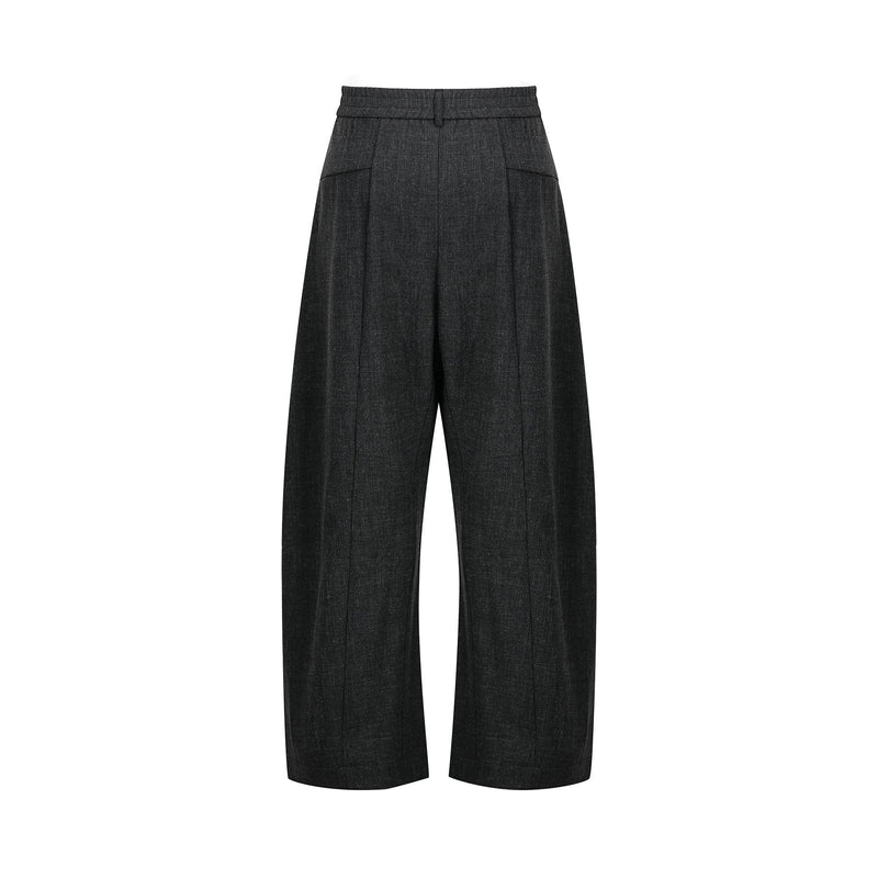 Back view of black pleated wide-leg pants with elastic waistband and side pockets