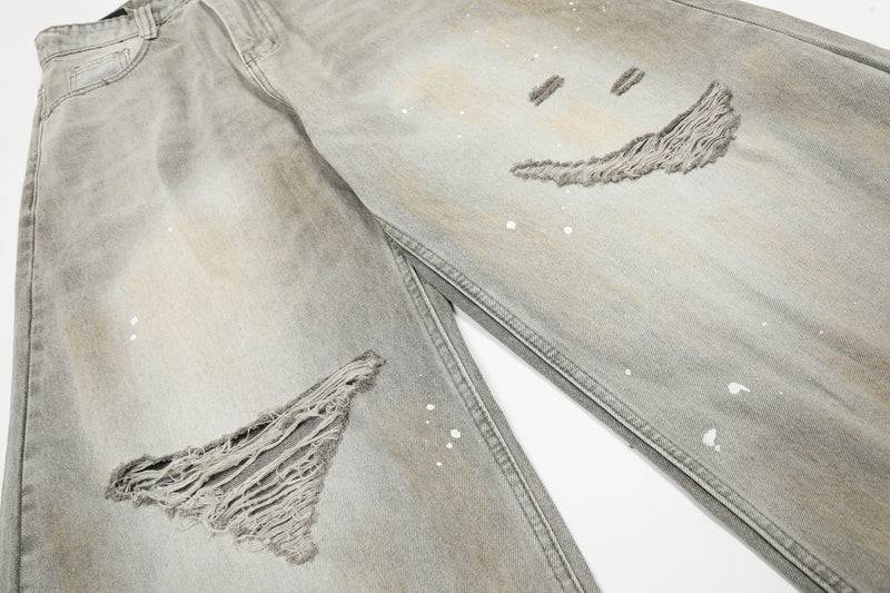 Wide-leg jeans laid flat with distressed knees and white paint splatter details
