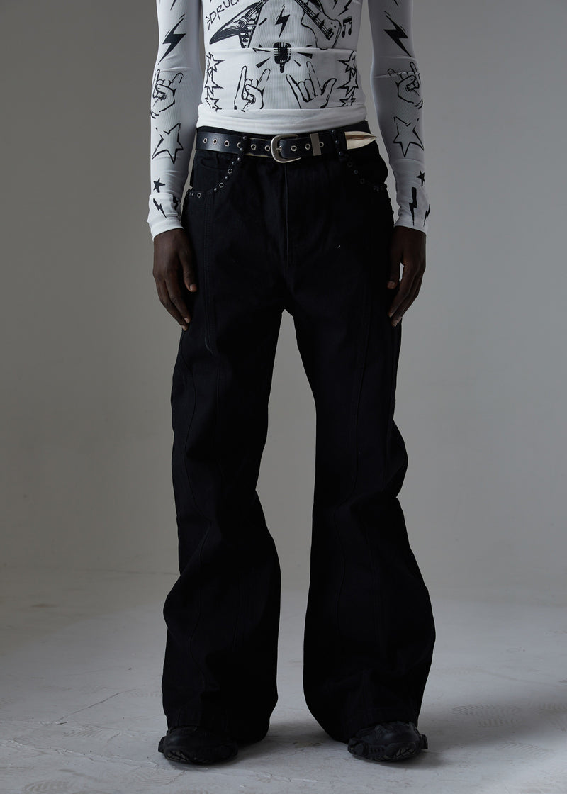 Model wearing black studded wide-leg jeans, front view with belt and dark streetwear top