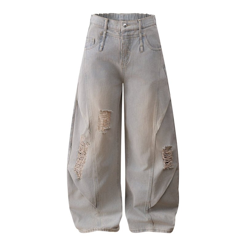 Front view of light wash wide-leg jeans with distressed rips and curved seams