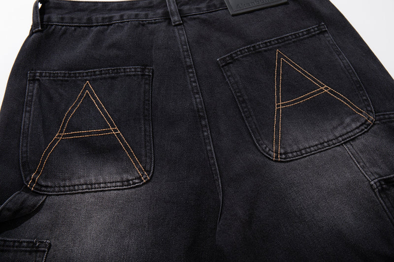Close-up of back pockets on black wide-leg carpenter jeans with tan A-shaped stitching