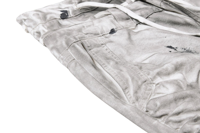 Side angle of gray wide-leg jeans showing gathered waistband and splatter details