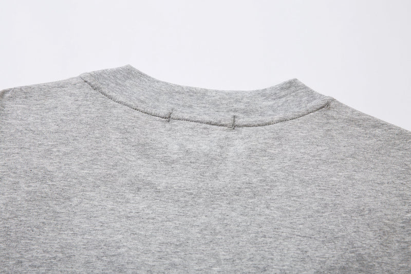 Close-up of the light gray tee back neckline with ribbed collar stitching