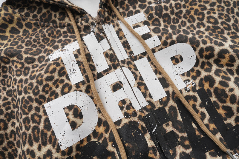 Front chest close-up of leopard print zip-up hoodie with white distressed lettering