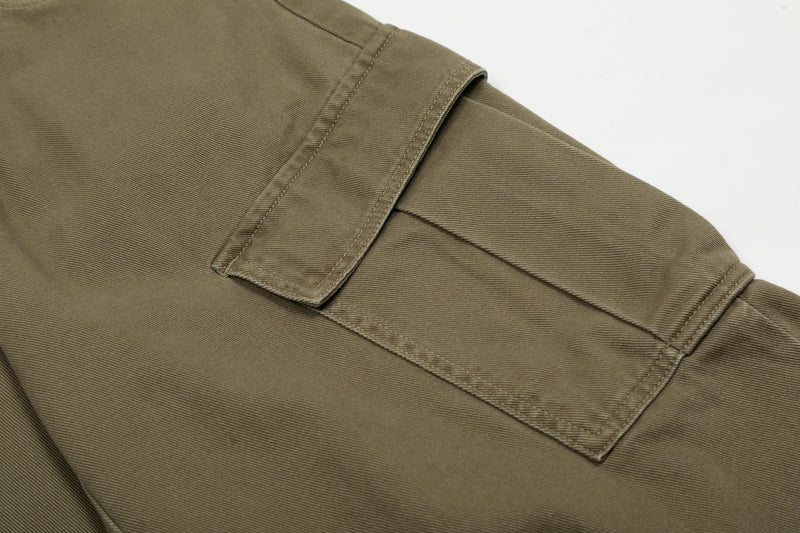 Close-up of olive cargo jeans side pocket and flap detail on the leg