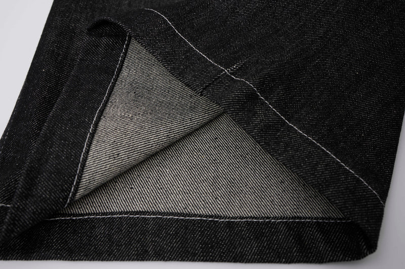 Close-up of black denim pocket lining and stitched seam detail
