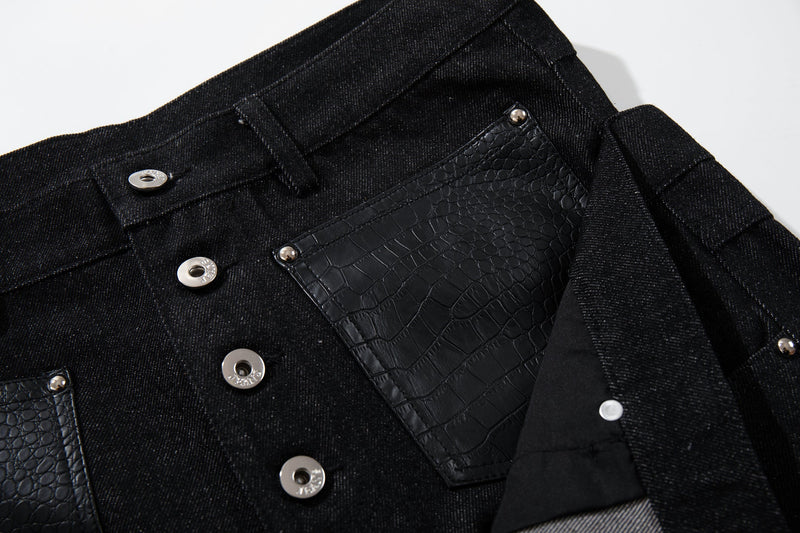 Close-up of front pocket and button fly details on black wide-leg denim pants