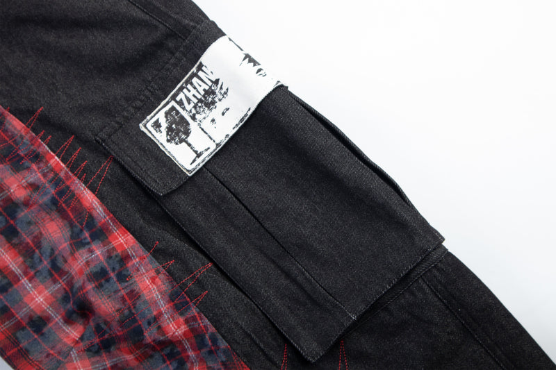 Close-up of side pocket flap with white printed patch on black cargo pants