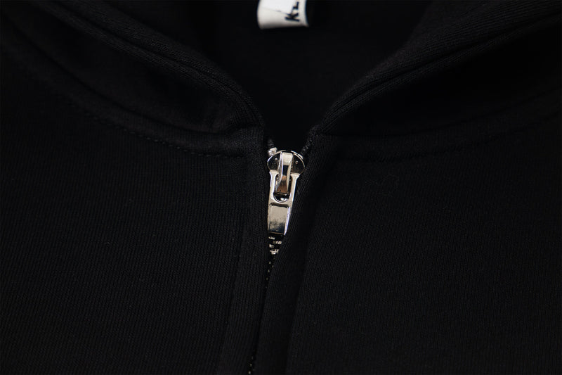 Close-up of black hoodie zipper and ribbed fabric texture