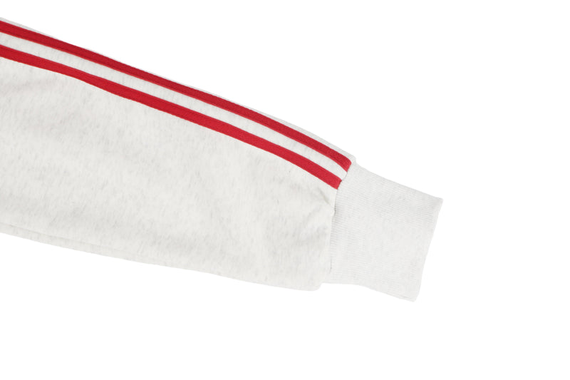 Close-up of white sleeve cuff with red double stripe detail
