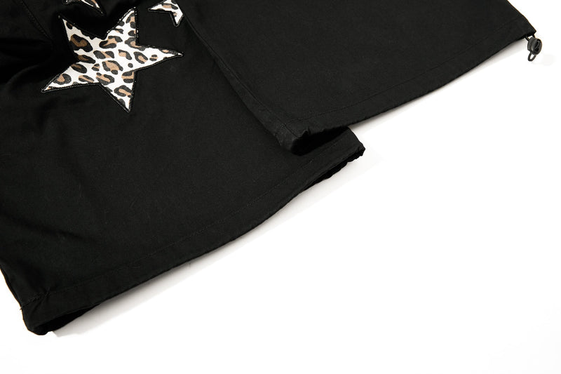 Close-up of black pants hem with leopard star patch and drawcord