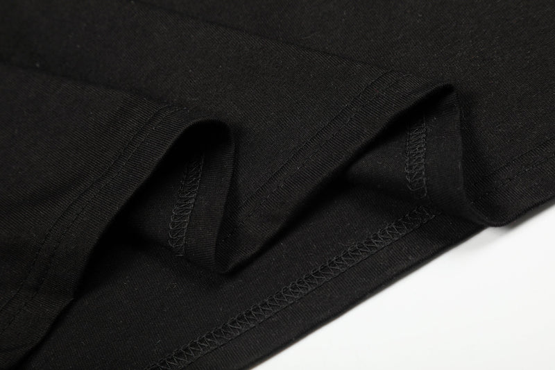Close-up of black tee sleeve cuff and hem stitching