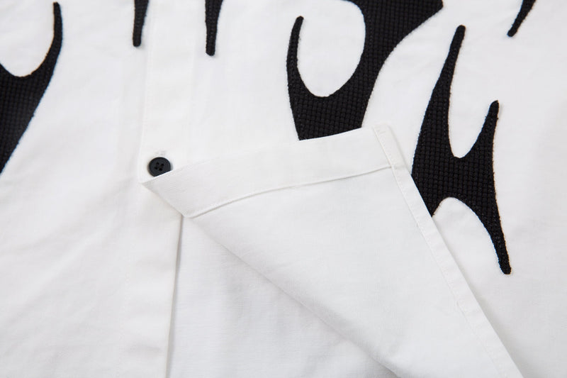 Close-up of white shirt cuff layered over black long sleeve