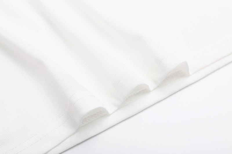 Close-up of soft white folded T-shirt fabric with visible seams and smooth cotton texture