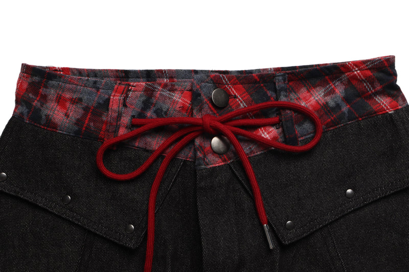 Close-up of red plaid waistband with red drawstring and snap buttons on black denim