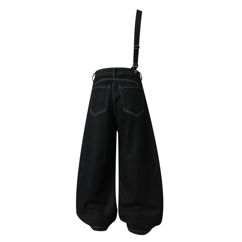 Back view of black wide-leg jeans with one long shoulder strap attached at the waistband