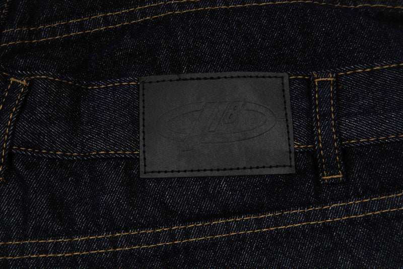 Close-up of black leather brand patch on the back waistband of denim shorts