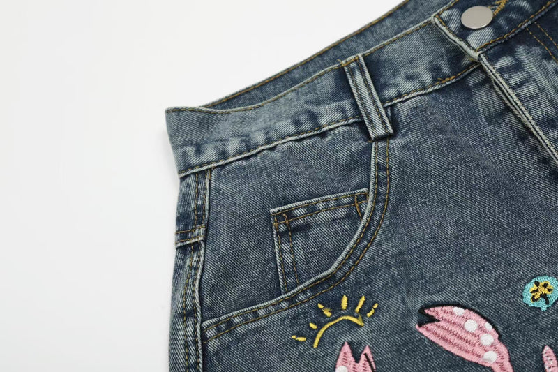 Close-up of front pocket and crab embroidery on blue denim jeans