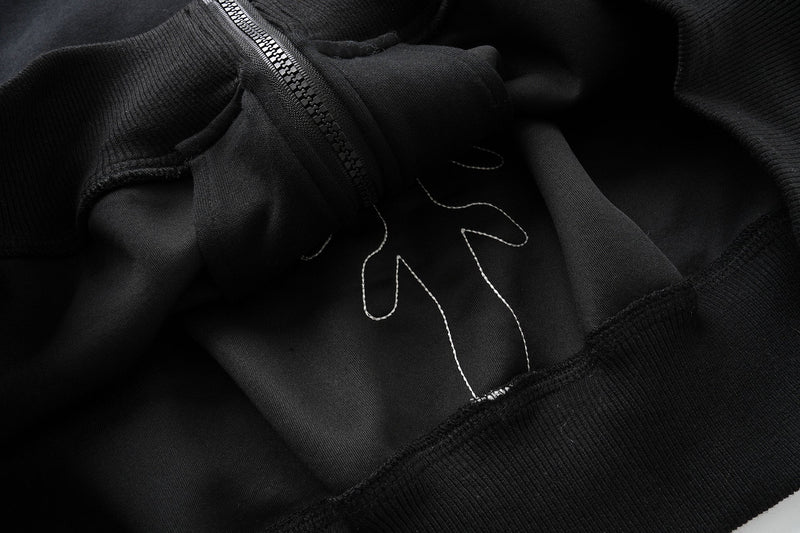 Close-up of inside front panel with stitched skeleton hand detail on black hoodie