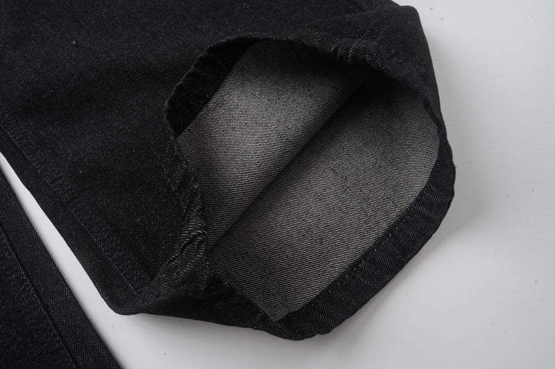 Cuffed black denim hem close-up with inner twill lining visible