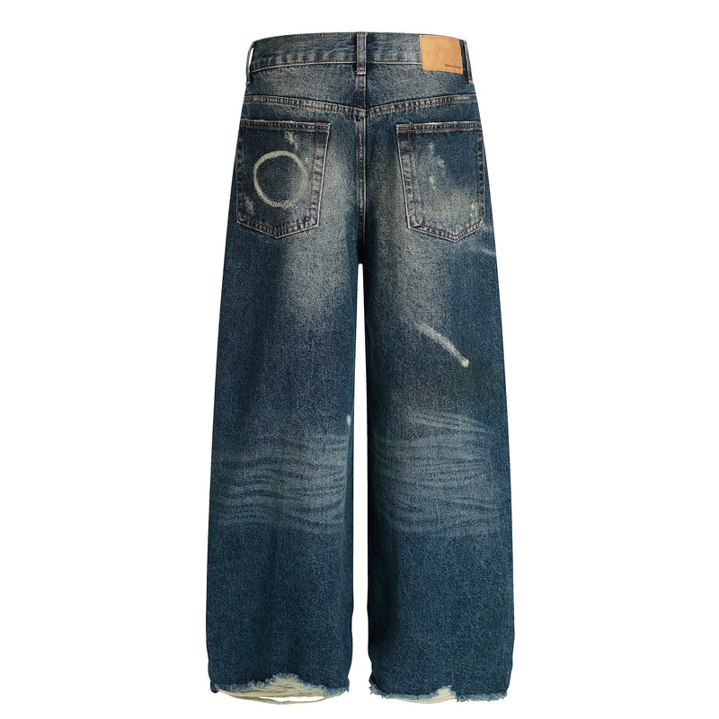 Back view of wide-leg jeans with faded wash, paint splatters, and patch pocket details