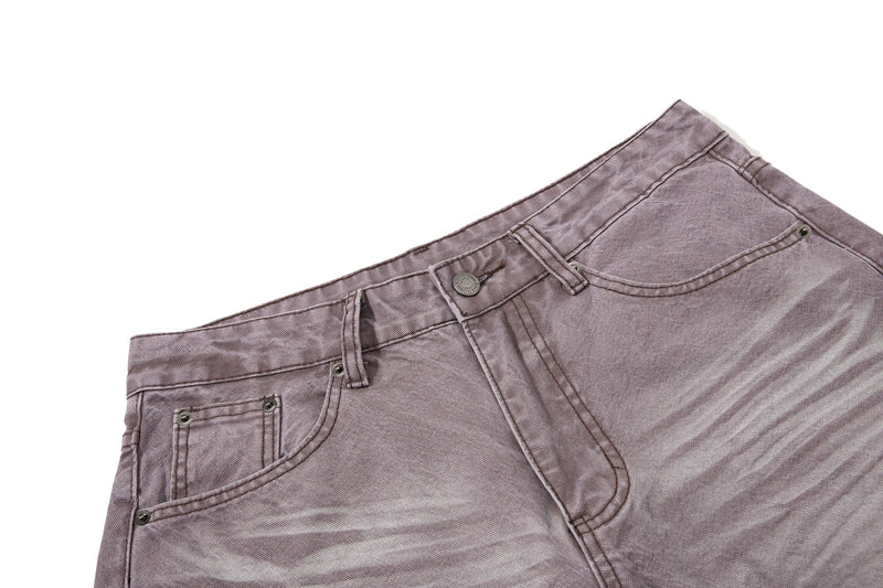 Close-up of brown denim waistband, button closure, belt loops, and front pocket