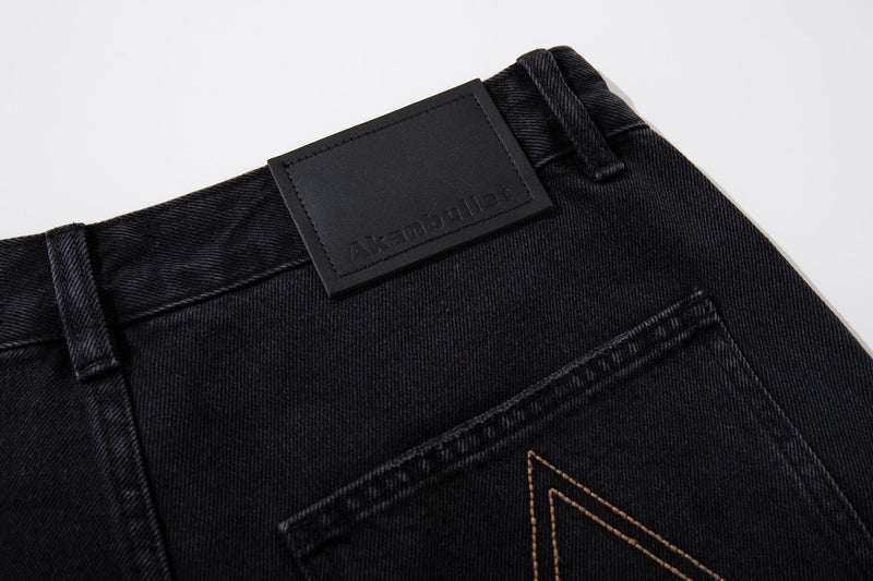 Close-up of black waistband and logo patch on carpenter jeans
