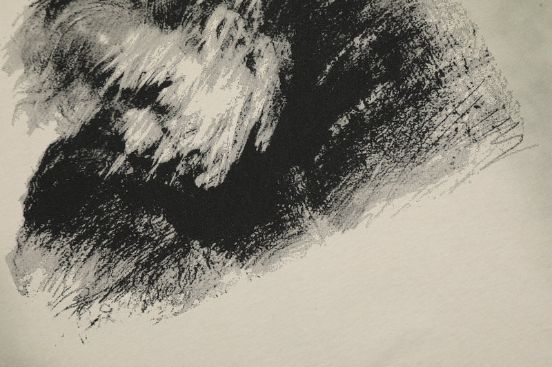 Black-and-white washed graphic tee print with abstract vintage portrait brushstrokes on cream fabric