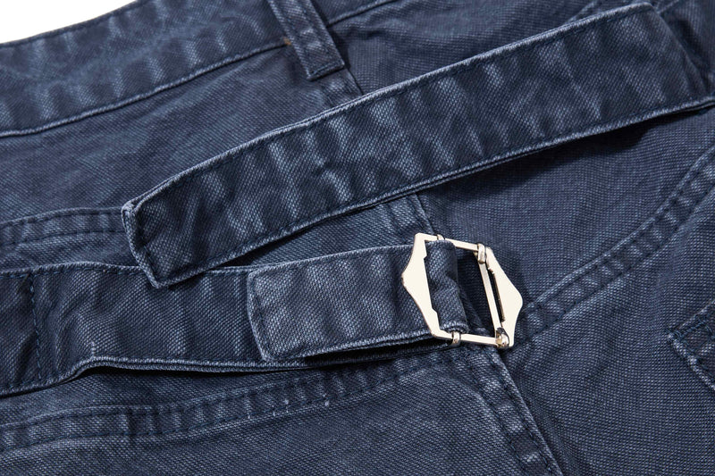 Close-up of dark wash denim shorts waistband buckle and belt strap