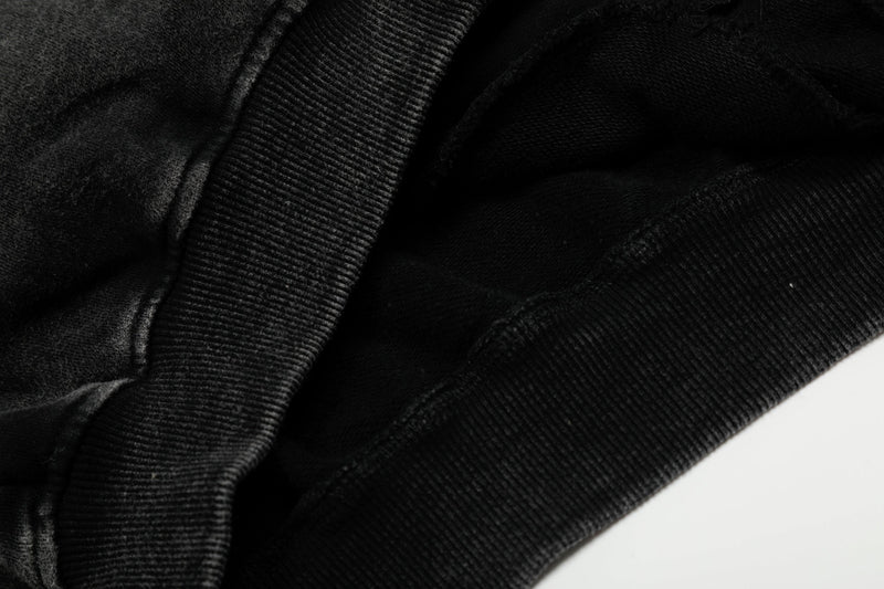 Close-up of black jacket fabric and ribbed trim at the hem