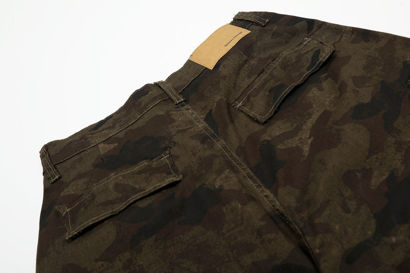 Back waistband close-up of camouflage cargo shorts with tan patch label