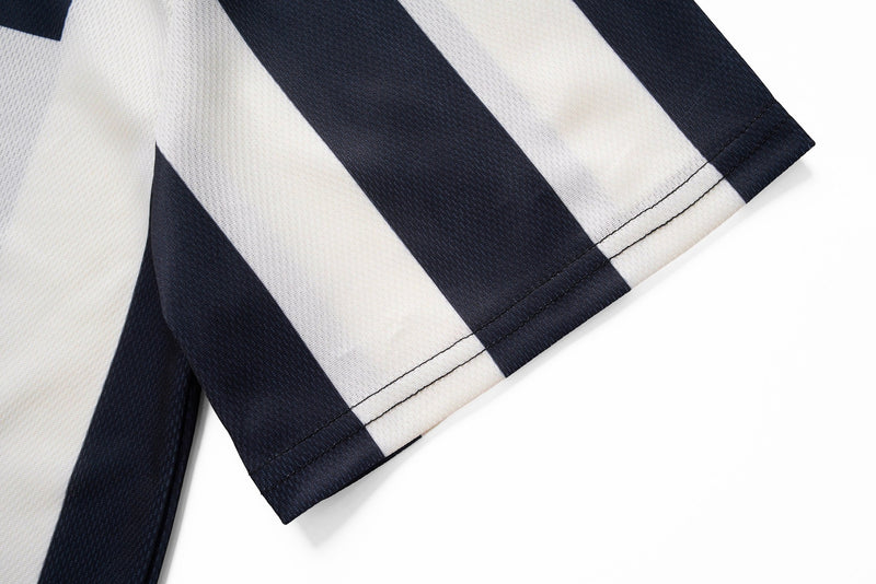 Close-up of a black and white striped varsity soccer jersey sleeve with clean stitched hem and retro sporty texture