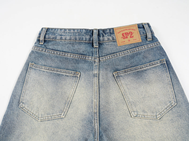 Back view close-up of two patch pockets and logo label on faded denim shorts